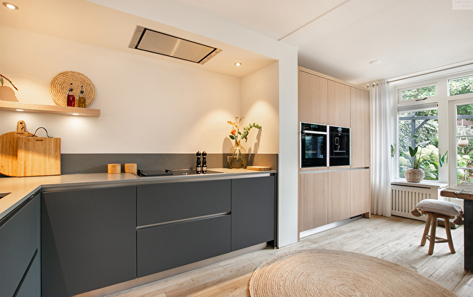 Greeploze designkeuken in zachte tinten met warme eiken accenten